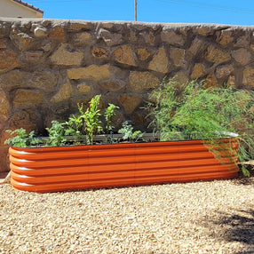orange metal planter box growing scallions in the backyard