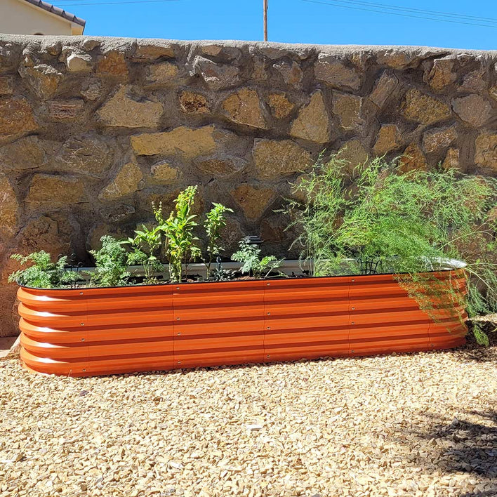 orange metal planter box growing scallions in the backyard